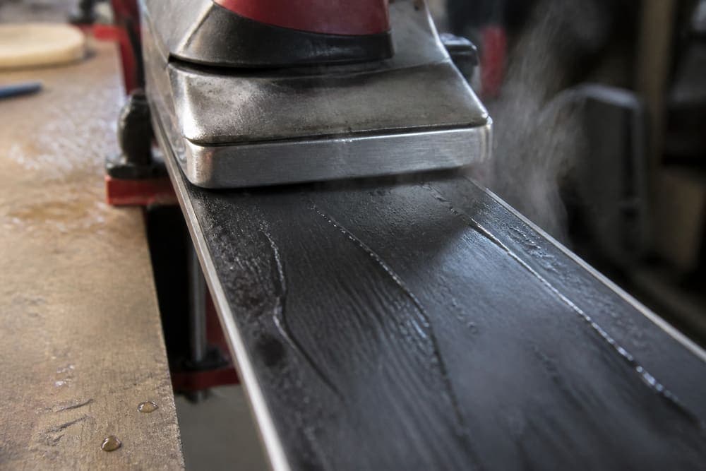 Hot wax being ironed onto a ski base